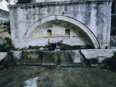 斑驳石墙下的古老喷泉静谧流淌