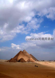 埃及金字塔矗立沙漠，驼队穿行