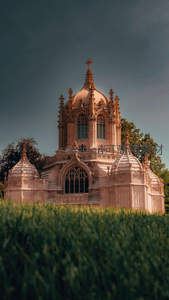 哥特式小教堂静立绿茵之上，阴云密布更显神圣