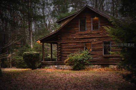 秋日森林中的原木小屋，暖光透窗显温馨