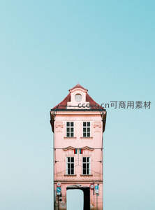 粉色尖顶塔楼在浅蓝天空下静谧矗立，充满童话色彩