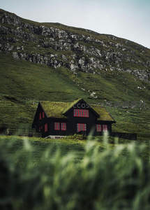 黑墙红窗草顶屋依山而建