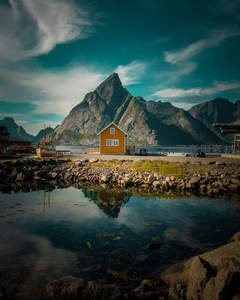 湖畔橙色小屋倒映峻峰