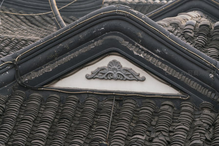 三角山墙上的浮雕花饰与黑瓦屋顶的和谐搭配