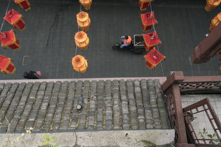 古街灯笼高挂，工人骑车穿行其间