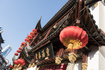 古建筑飞檐下悬挂的红灯笼与蓝天相映成趣