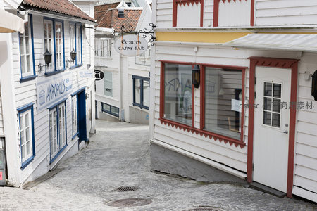 鹅卵石街道两旁是彩色窗框的白色木屋