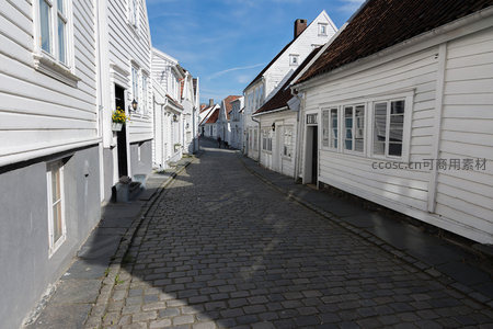 阳光下的白色木屋巷道，蓝天映衬如画