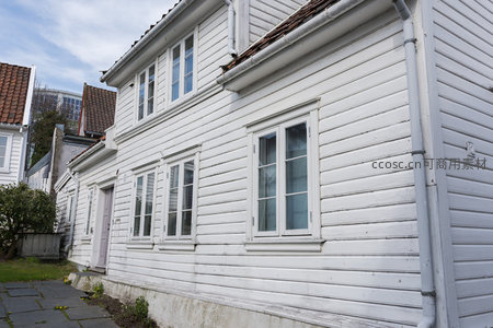 阳光下的白色木屋外墙与窗户