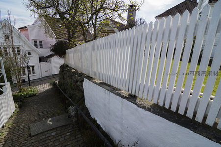白色栅栏沿坡而上，绿树掩映欧式庭院