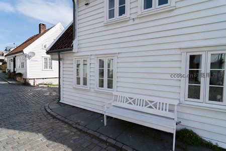 白色长椅静置于木屋旁的悠闲角落