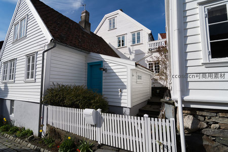 蓝门白屋与栅栏围起的私密庭院