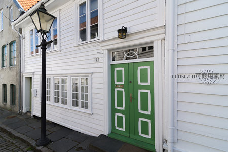 绿门白墙老宅配复古路灯显古韵