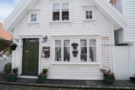 绿门白墙小屋窗台花篮点缀