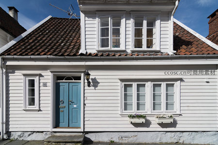 蓝门白墙老屋阁楼窗户映蓝天