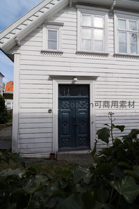 白墙蓝门老宅前绿植环绕静谧宜人