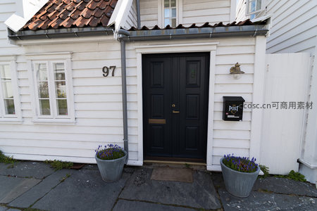 门牌97号白墙黑门，两侧紫花点缀雅致