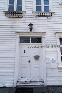 白色木门饰藤心挂件，复古灯笼映衬怀旧