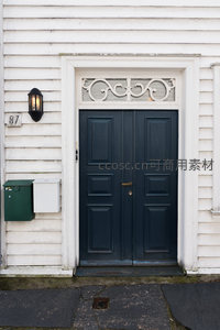 深蓝双开门配白色雕花门楣的古典住宅入口