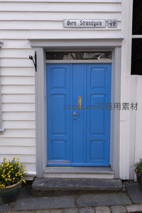 亮蓝双开门映白墙，街牌花盆添生气