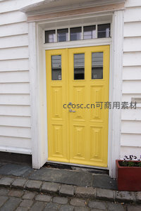 明黄双开门透窗格，白墙石路显明媚