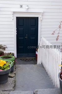 深蓝大门旁白色栅栏与花盆的庭院小径