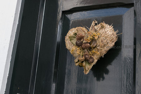 心形干草花环装饰在黑门上