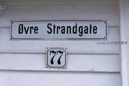 白色墙面上的街道名称与门牌号标识
