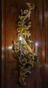 鎏金雕花壁灯照亮深色木墙