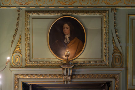 圆形肖像画悬于雕花壁龛之上