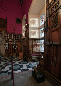 中世纪城堡大厅，盔甲陈列于彩窗与木雕之间