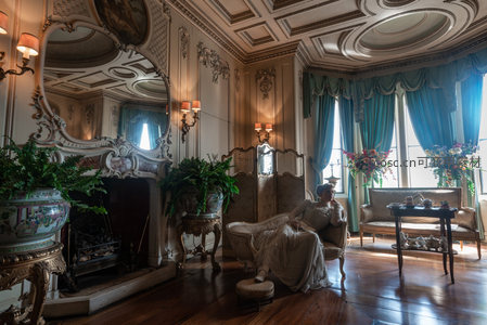 贵妇倚坐华丽客厅，水晶吊灯映典雅