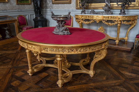 鎏金圆桌配红绒台面，雕花腿足显华贵