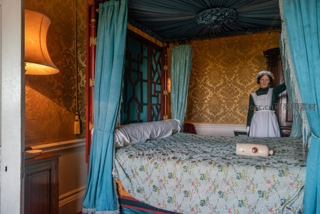 蓝绿帷幔古床，女仆人偶静立床畔