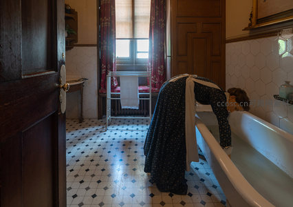 复古浴室中女仆弯腰清洁浴缸的瞬间