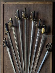 木质展板上陈列的多把复古军刀特写