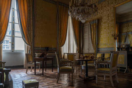 金黄大厅静谧，水晶吊灯映照古典桌椅