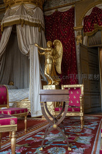 金翼天使雕像立于宫廷卧室，红幔垂落华贵非凡