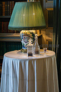 书房角落静谧优雅，青瓷台灯与水晶酒具