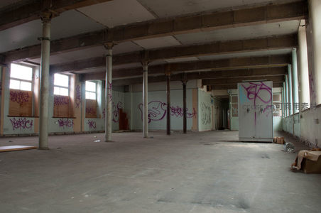废弃工厂内部，涂鸦覆盖的空旷大厅