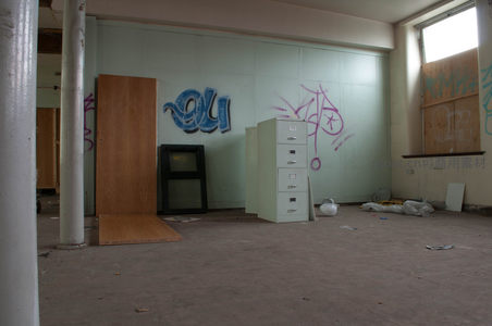 废弃房间角落，文件柜与涂鸦墙并存