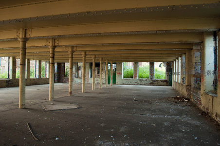 废弃工厂内部空旷走廊与斑驳立柱