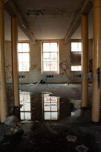 水洼倒映窗影的废弃车间