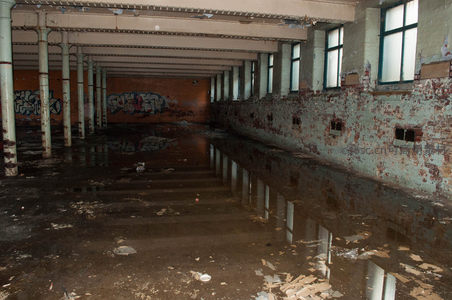 涂鸦墙边废弃厂房长廊积水