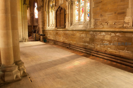 阳光穿透石墙洒在教堂空旷长廊