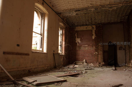 阳光穿透破窗，照亮砖墙裸露的废弃空间