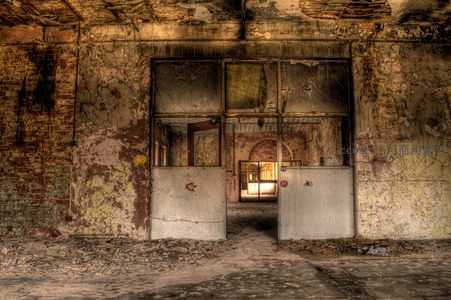 破败厂房大门后透出温暖夕阳