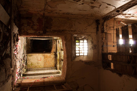 从破败门洞望向幽深楼梯间