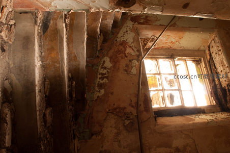 阳光照亮残破楼梯与斑驳墙面