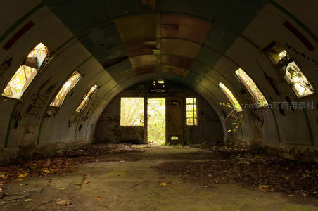 拱形废弃走廊布满落叶与涂鸦